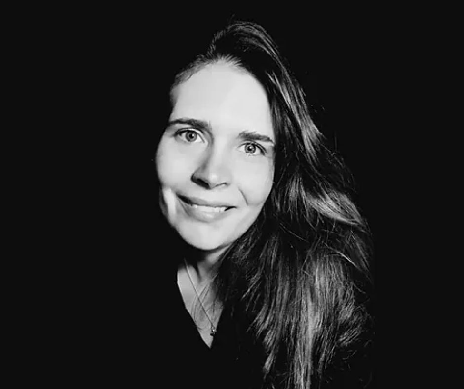 Præst Jette Rosendal i præstekjole med en bibel i hånden